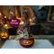 A hand carved pumpkin gourd. She is a cute little witch named Vivian. She has a custom witch hat and is lit with a battery-operated candle.